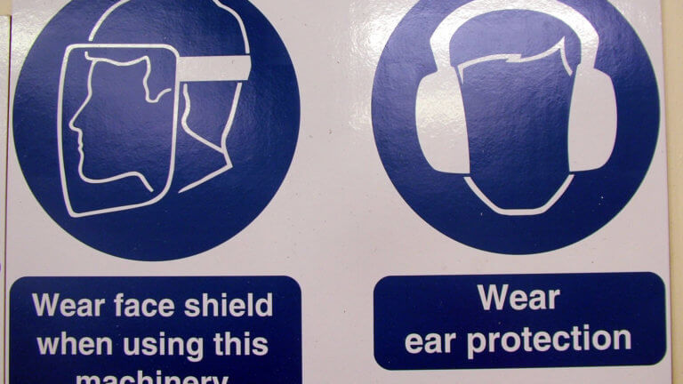 Image of a safety sign instructing to wear face shield and ear protection
