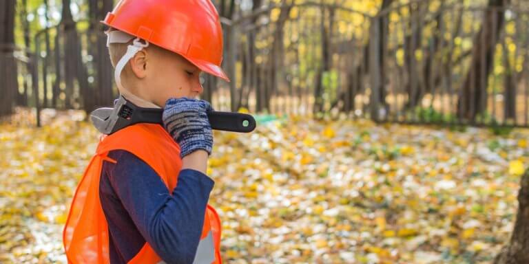 Child dressed in a hard hat and hi-vis, dressed as a contractor working.