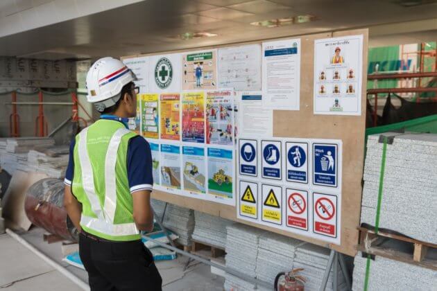 The engineer reading notice board of workplace health and safety policy before working in construction site